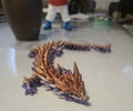 3D Print NZ articulated dragon figurine toy with copper and purple gradient, segmented body, and detailed scales.